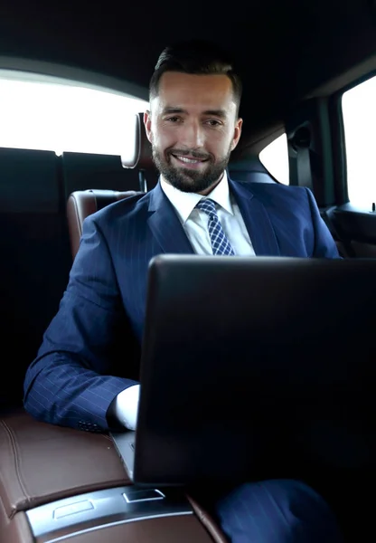 Erfolgreicher Mann sitzt auf dem Rücksitz eines Autos — Stockfoto