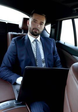 işadamı ile rahat bir arabada oturan laptop