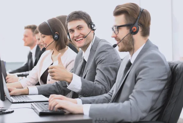 Call center empregado com fone de ouvido mostrando polegar para cima — Fotografia de Stock