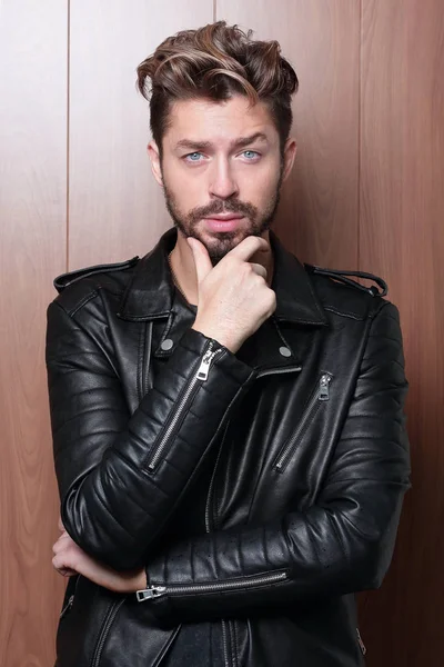 Man fashion in leather jacket, wooden background — Stock Photo, Image