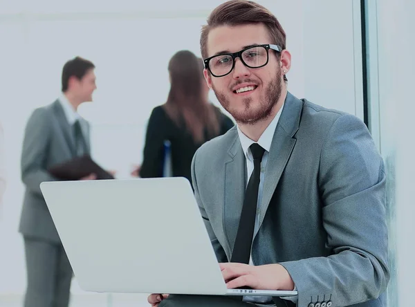 Retrato de un joven hombre de negocios guapo con gente de fondo en la reunión de la oficina — Foto de Stock