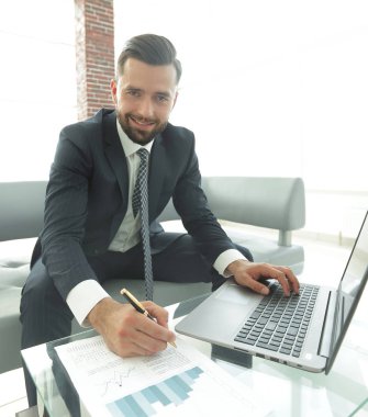 Dizüstü bilgisayarda çalışan ve Notlar not defterinde yapma şık adam