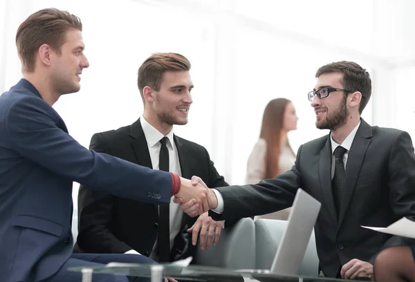 Partner bei Vertragsabschluss und Händeschütteln im Beisein von Teammitgliedern — Stockfoto