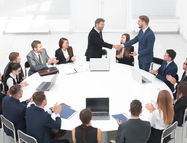 Partnerzy biznesowi uścisnąć dłoń podczas rozmów w pobliżu okrągłego stołu — Zdjęcie stockowe