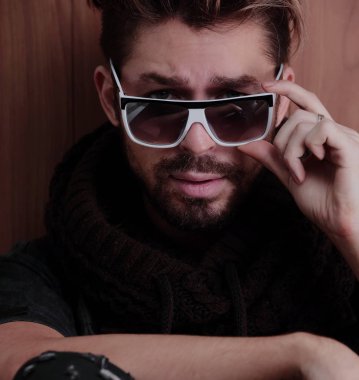 Ahşap duvara yaslanmış yakışıklı bir adamın portresi..