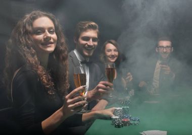 Casino oyun masasında oturan arkadaş grubu