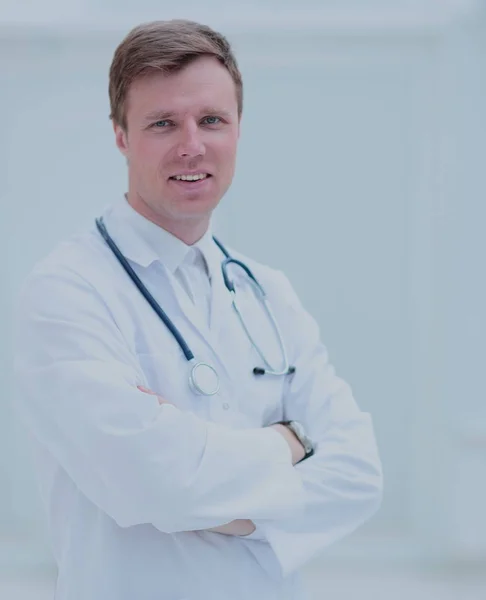 Porträtt av säker manliga läkare med armar korsade stående vid — Stockfoto