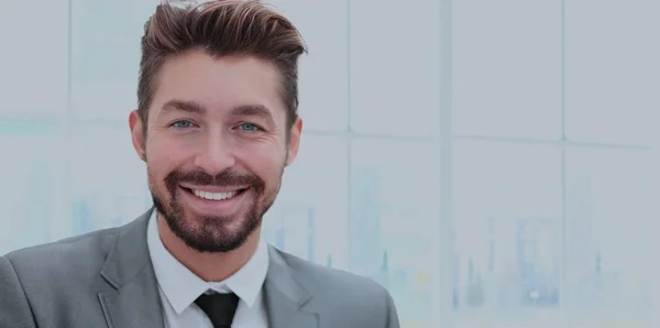 Hombre de negocios guapo en una oficina con fondo borroso — Foto de Stock