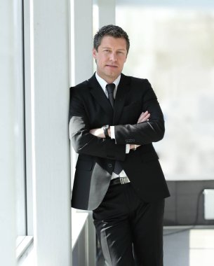 ofis koridorunda duran ciddi iş adamı.