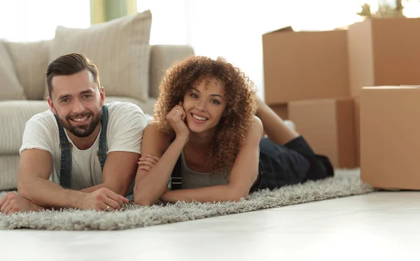 Lyckliga par ligger på golvet i en ny lägenhet — Stockfoto