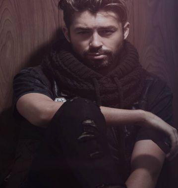 Ahşap duvara yaslanmış yakışıklı bir adamın portresi..