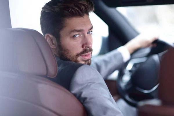 Primer plano de un hombre de negocios sentado al volante de un coche — Foto de Stock