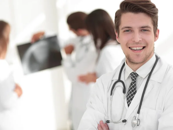 Unga läkare på bakgrunden av kollegor — Stockfoto