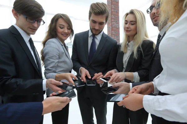 Närbild av smartphones i händerna på företag ungdomar — Stockfoto