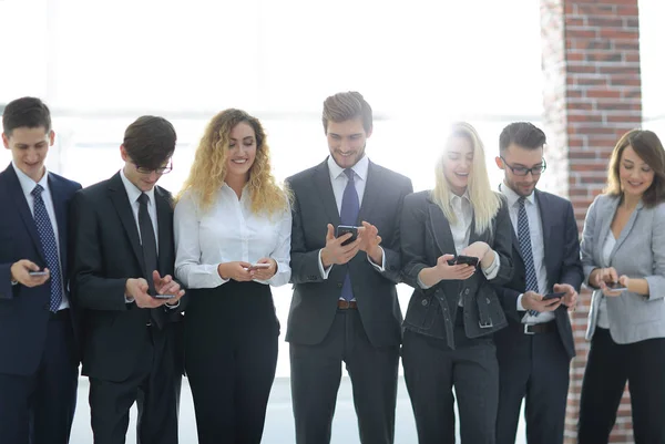 Üzleti csapat látszó-hoz smartphone-ban Hivatal — Stock Fotó