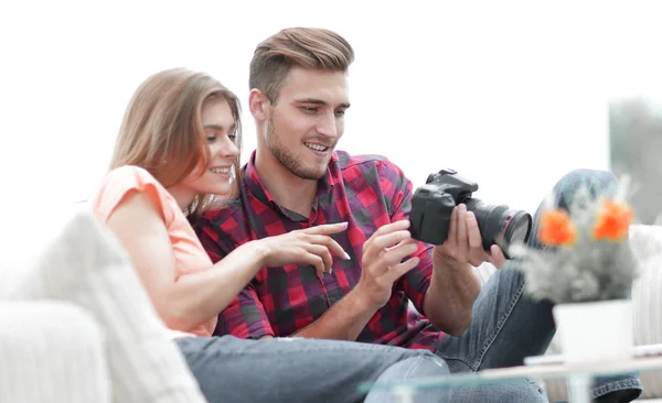 Jovem casal moderno verifica as fotos na câmera — Fotografia de Stock