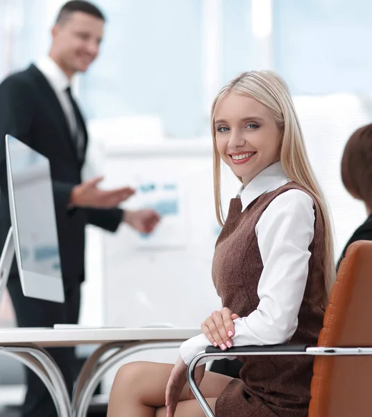 Succesvol zakenvrouw, zitten aan een bureau in de achtergrond van het bedrijf-team. — Stockfoto