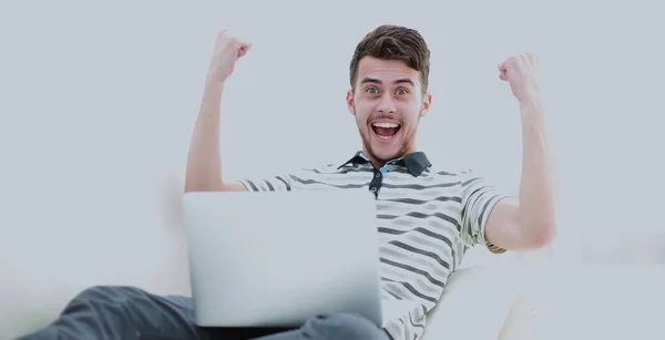 Joven feliz usando su portátil en la sala de estar luminosa . — Foto de Stock