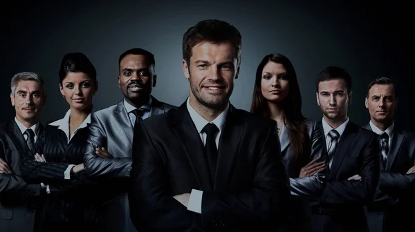 Equipe de negócios em pé sobre um fundo escuro — Fotografia de Stock