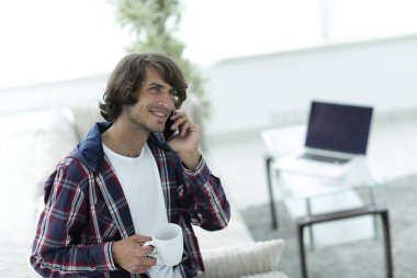 güzel bir fincan adamla bir dizüstü bilgisayar önünde oturur.