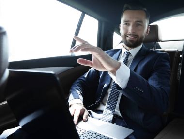 parmağını ileriye dönük ve arabanın arka koltukta oturan işadamı