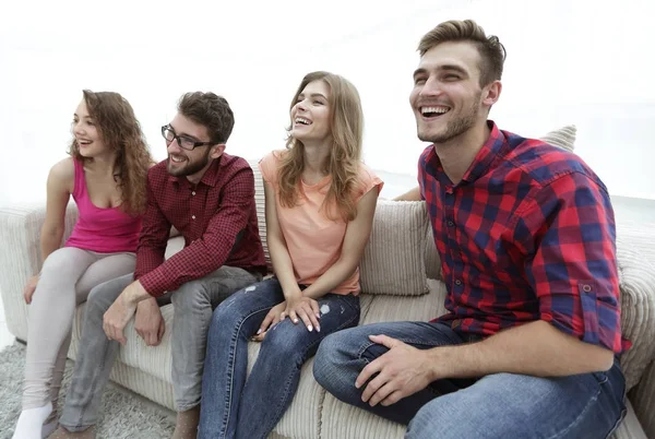 Grupo de jóvenes sonrientes sentados en el sofá —  Fotos de Stock