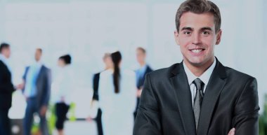 ofisinde memnuniyeti ile kameraya bakarak mutlu olgun iş adamı