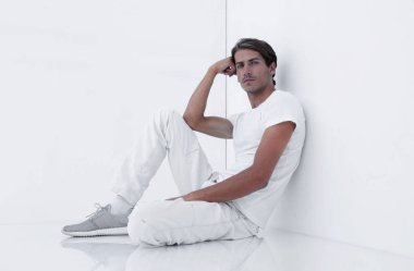 Beyaz bir duvar oturan endişeli adam