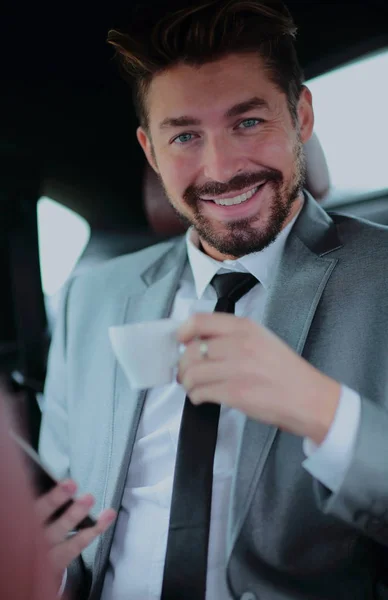 Un bell'uomo d'affari che prende un caffè in macchina — Foto Stock