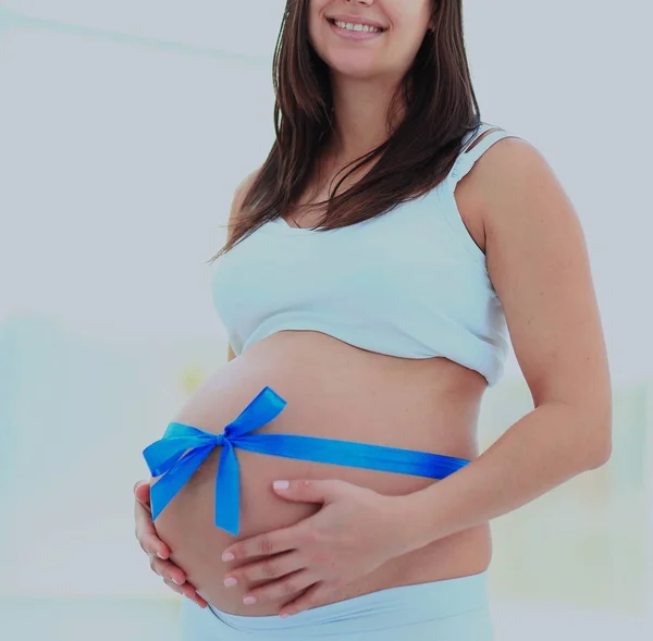 Щаслива вагітна жінка посміхається. дивлячись на камеру — стокове фото