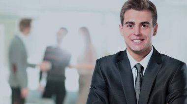 ofisinde memnuniyeti ile kameraya bakarak mutlu olgun iş adamı