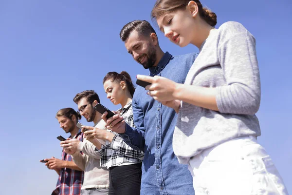 Young people using smartphones to search network — Stock Photo, Image