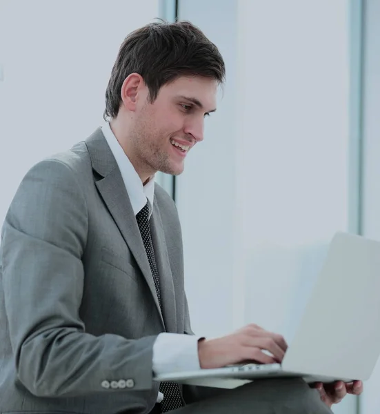 Smiling student blogger with an open laptop sitting near the win — Stock Photo, Image