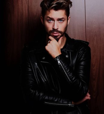 Sakallı yakışıklı emin olgun adam ahşap kahverengi üzerine duruyor