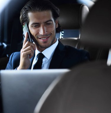 Yakışıklı işadamı cep telefonu arabaya kullaranarak.