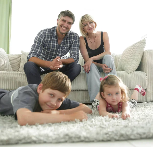 Retrato de família feliz sentados juntos na sala de estar — Fotografia de Stock