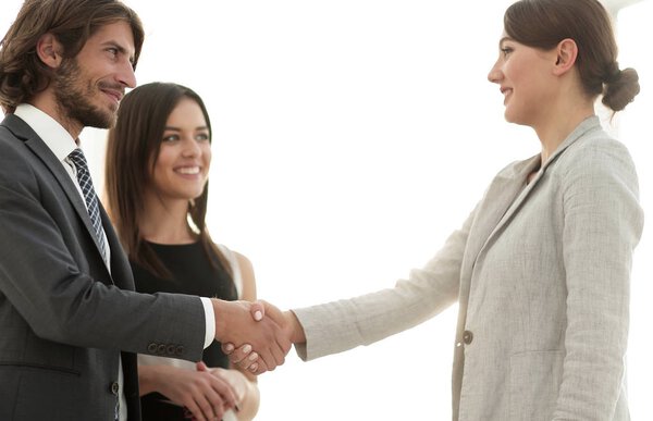 Бизнесмены пожимают руки в комнате с большим оконным туалетом