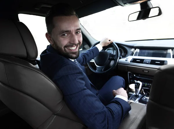 Successful man sitting behind the wheel of a prestigious car