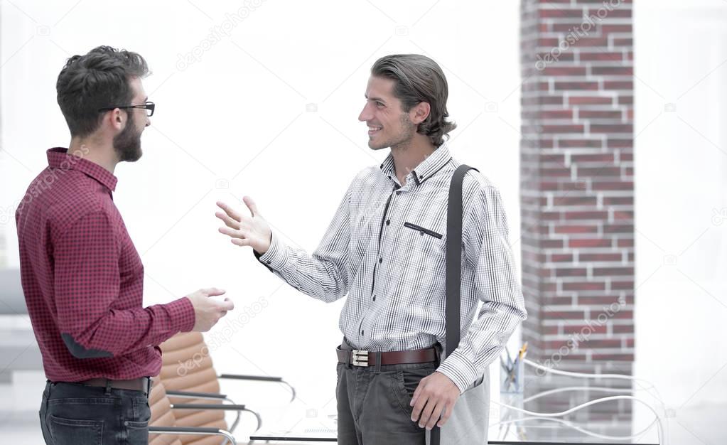 two employees are talking in the office