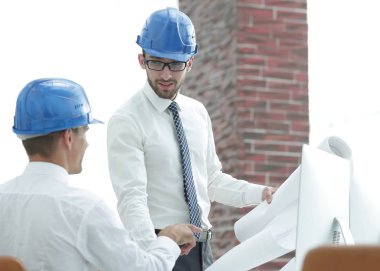 yeni bir projeyi tartışmak üzere mimar ve inşaat ustabaşı