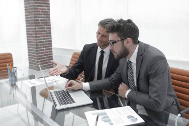 dizüstü bilgisayarda çalışan iki iş adamları.