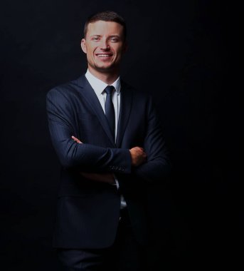 Siyah arka plan üzerine gülümseyen yakışıklı iş adamı