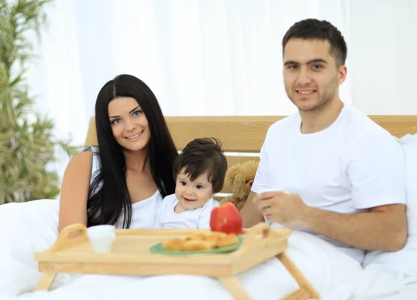 Família tomando café da manhã na cama em casa — Fotografia de Stock