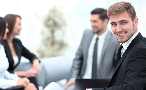 Успешный бизнесмен в офисе на фоне бизнес-команды — стоковое фото
