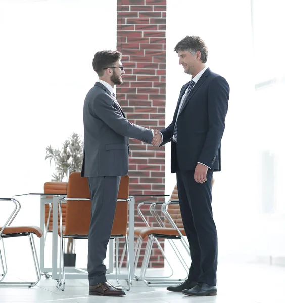 Dois empresários apertam as mãos no escritório — Fotografia de Stock