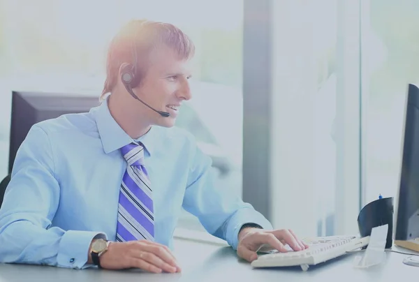 Jovem feliz trabalhando no call center, usando fone de ouvido — Fotografia de Stock