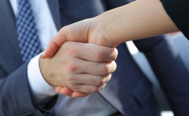 Businessman shaking hands to seal a deal with his partner clipart