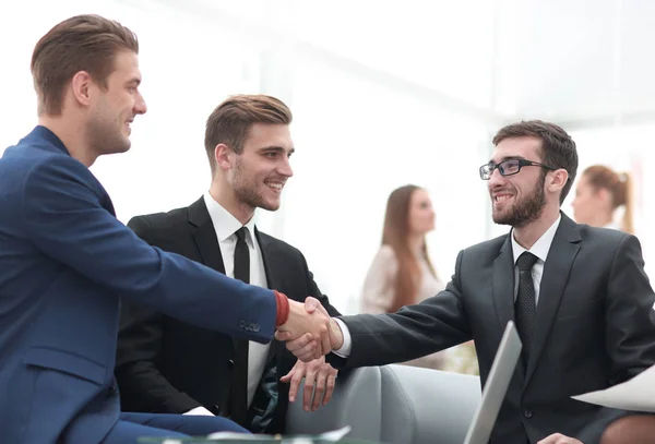 Partners ingår avtal och skakar hand i närvaro av lagmedlemmar — Stockfoto