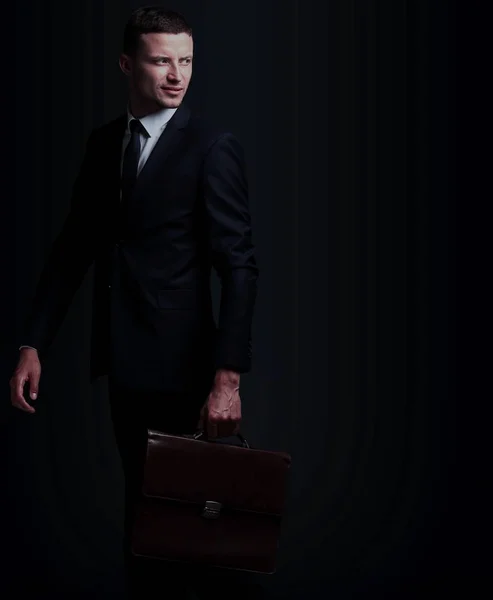 Портрет бизнесмена с портфелем, изолированным на черной набережной — стоковое фото