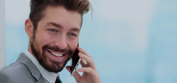 Yakışıklı iş adamı smartphone kullanarak bir ofiste — Stok fotoğraf